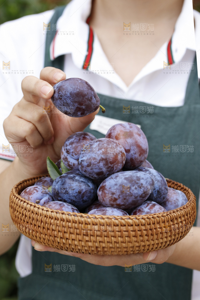 手上拿着一筐新鲜大西梅