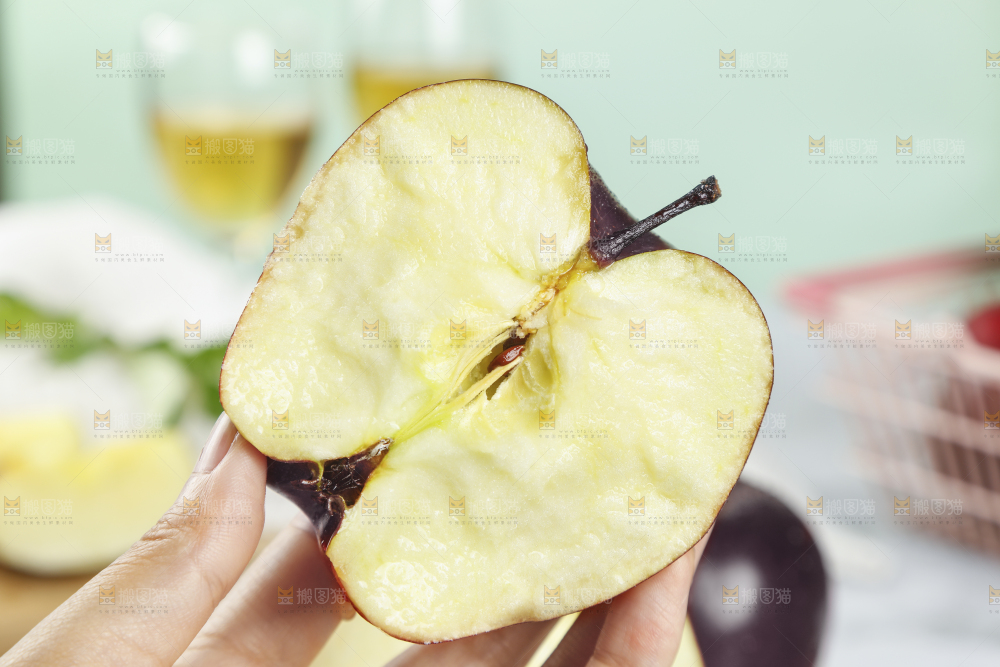 手上拿着新鲜黑苹果