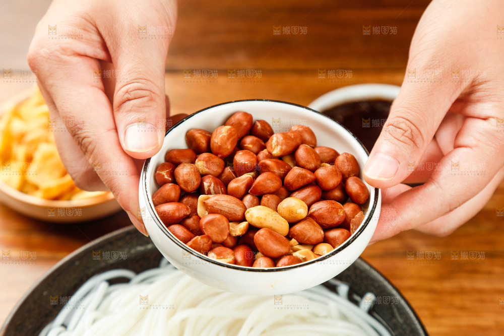 手端着一碟花生米