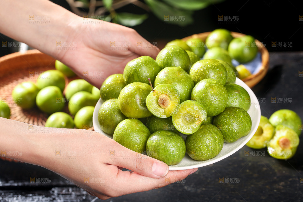 手端着一盘新鲜青脆李