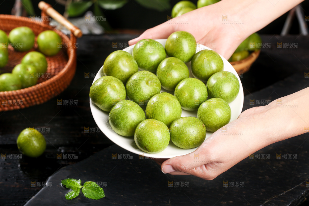 手端着一盘新鲜青脆李