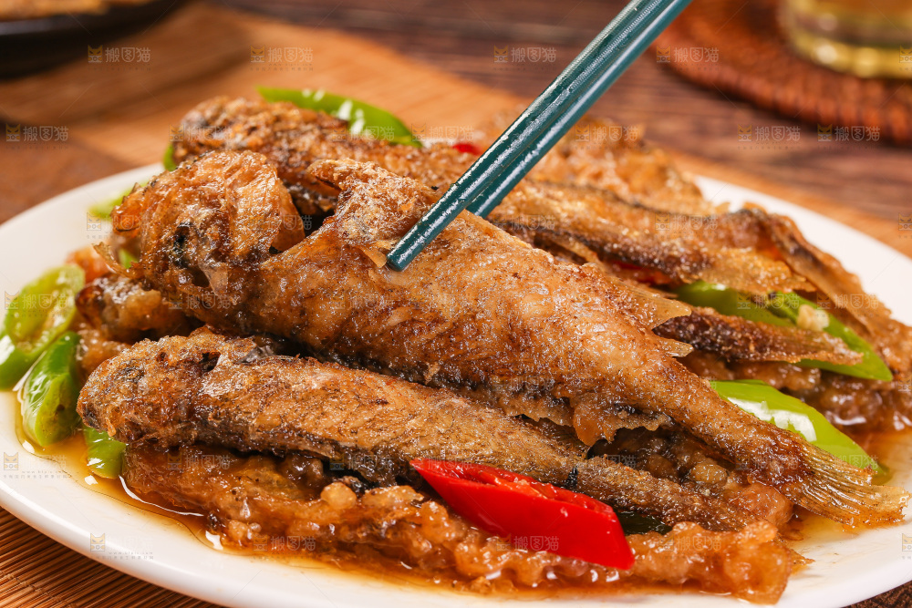 筷子上夹着香酥煎鱼