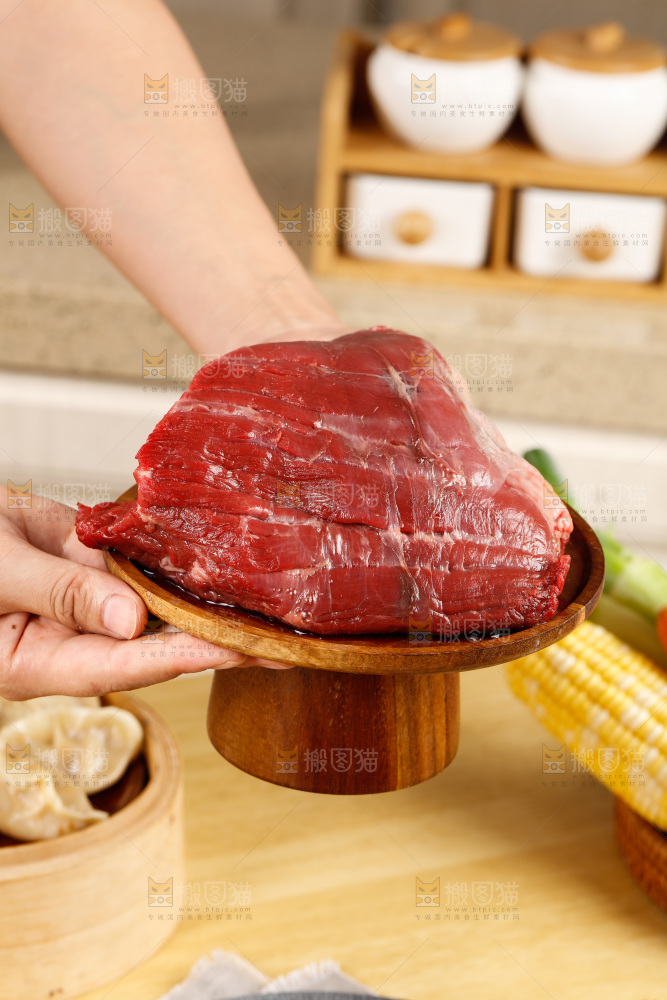手端着一盘生牛肉