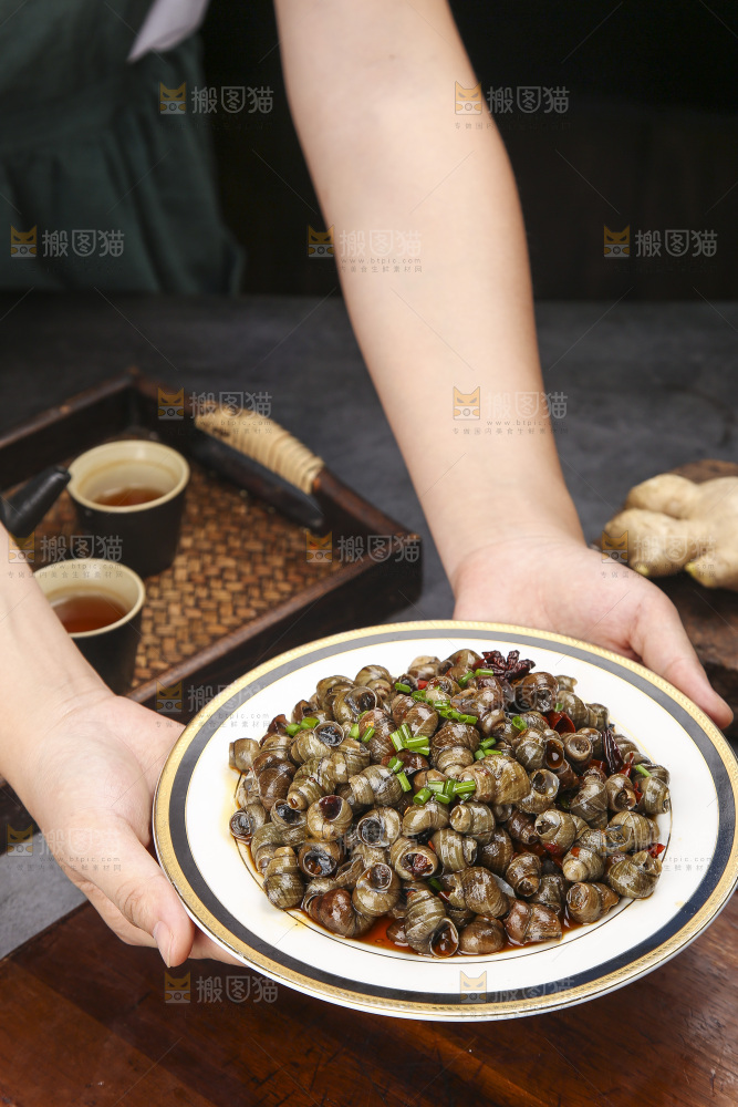 手端着一盘香辣田螺