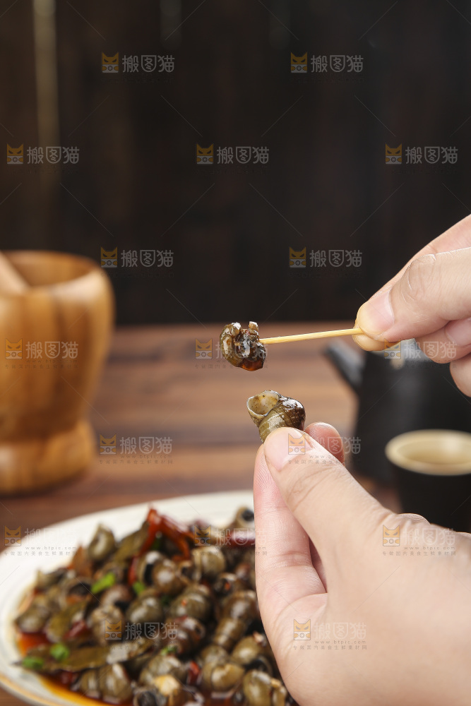 手里拿着牙签挑田螺肉