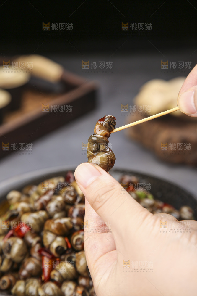 手里拿着牙签挑田螺肉