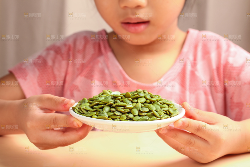 女孩手拿一盘南瓜子仁