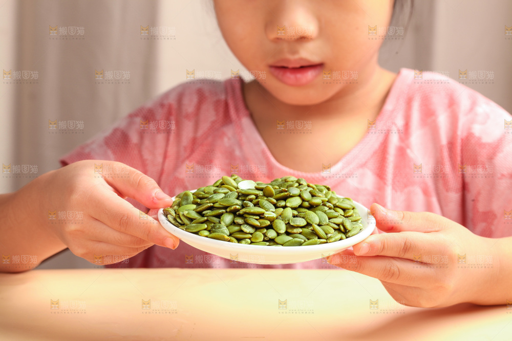 女孩手拿一盘南瓜子仁