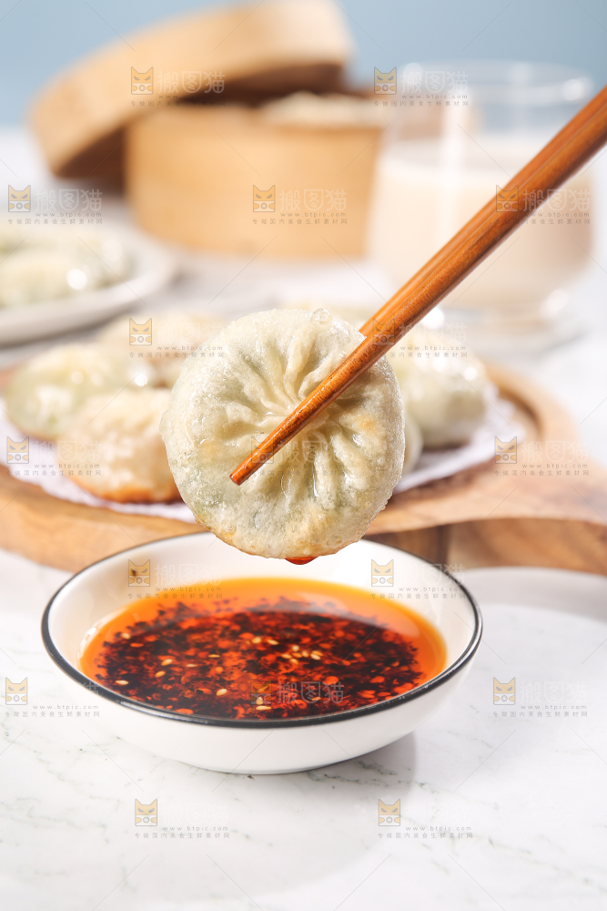 筷子夹着蘸酱的小包子