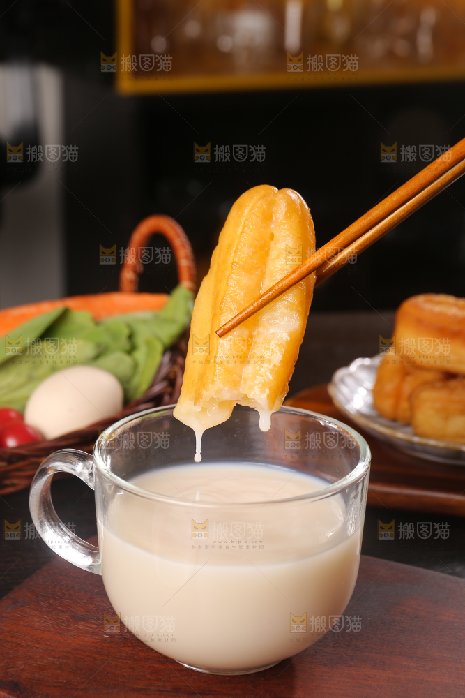 筷子夹着豆浆蘸油条