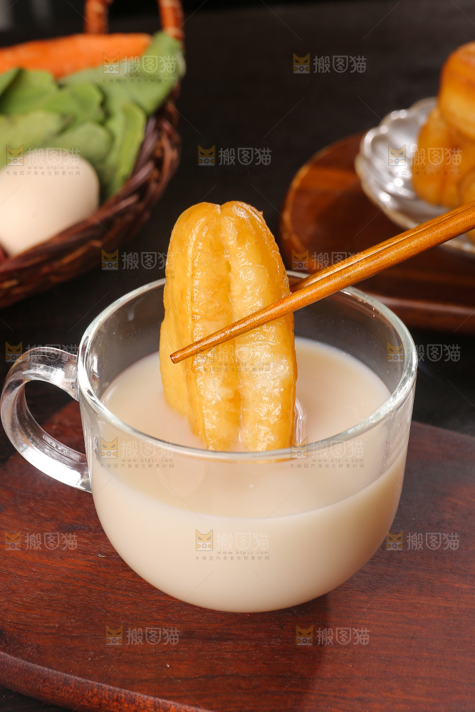 筷子夹着豆浆蘸油条
