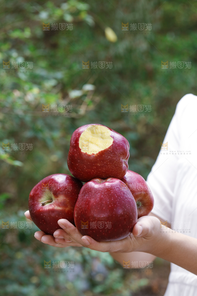 手里拿着咬开的花牛苹果
