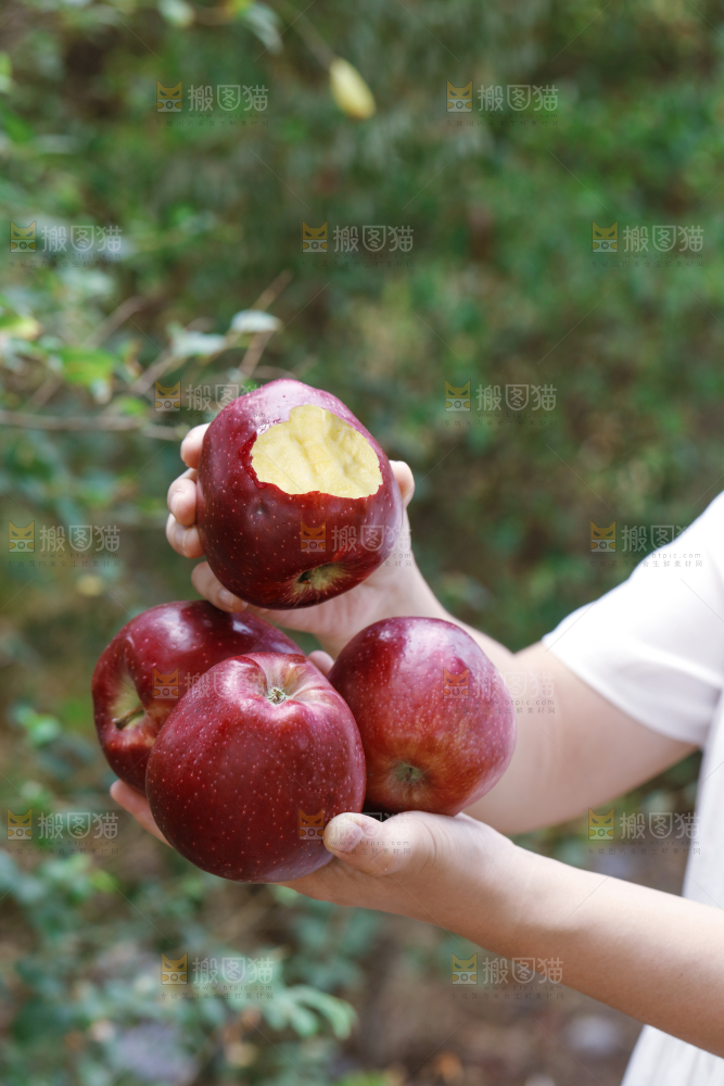手里拿着咬开的花牛苹果