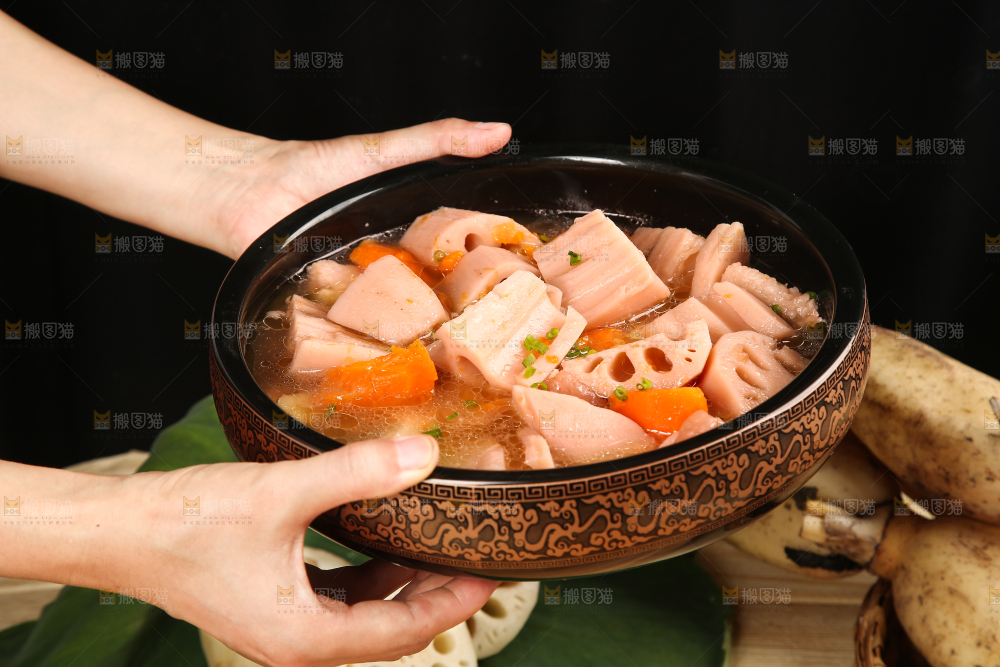 手里端着一碗胡萝卜粉藕汤