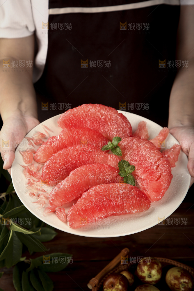 手里端着一盘红心蜜柚果肉