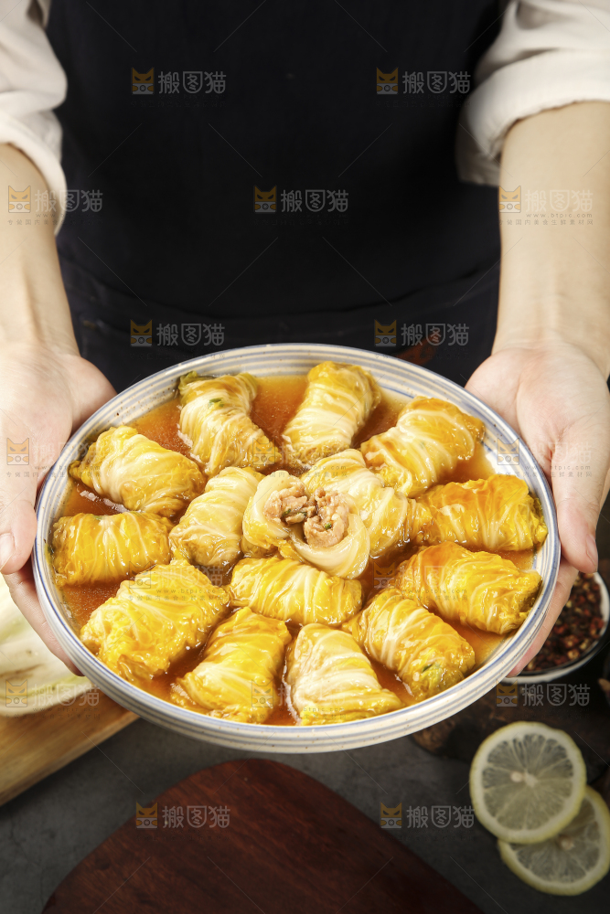 手里端着一盘白菜酿肉卷