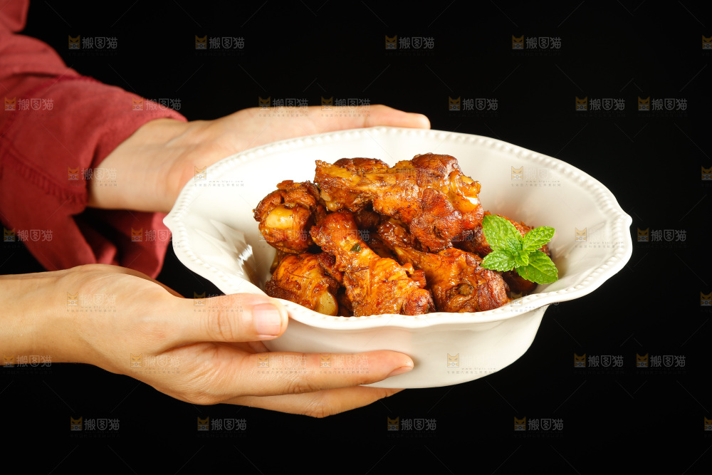 手里端着一盘红烧小鸡腿