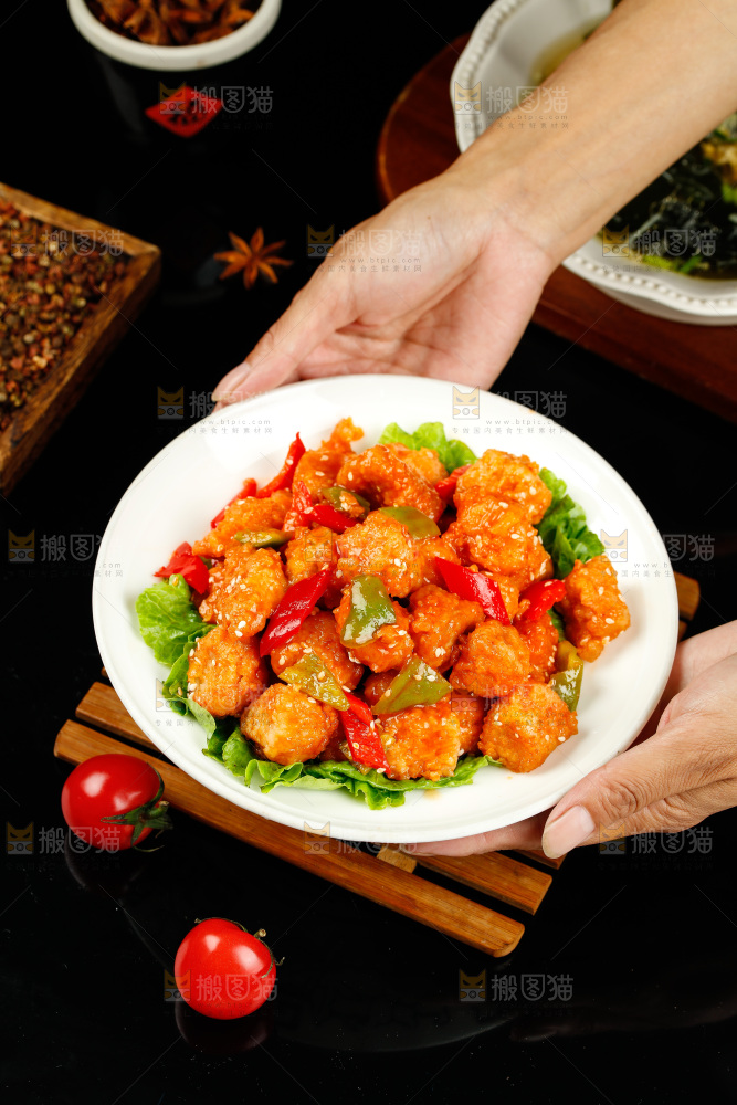 手里端着一盘香辣咕咾肉
