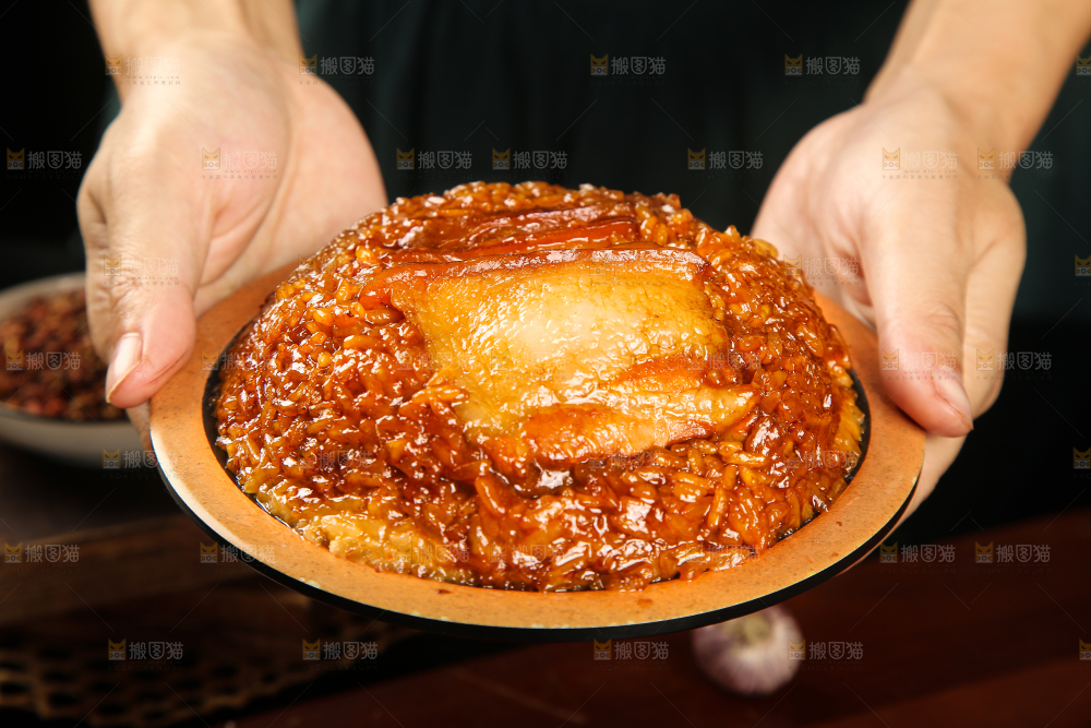 手里端着一盘甜烧白