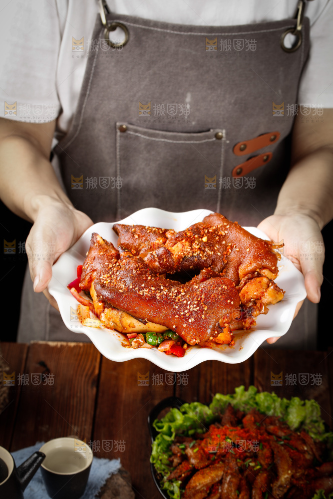 手里端着一盘香酥烤猪蹄