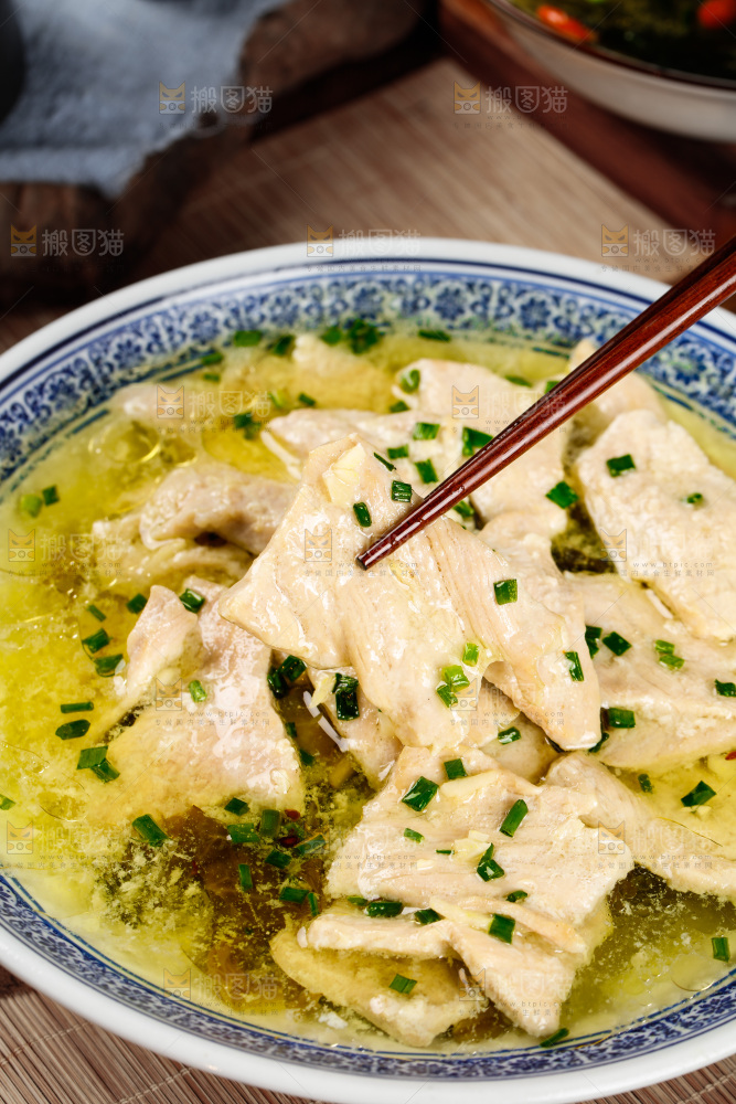 一碗酸汤肉片和筷子上夹着肉片