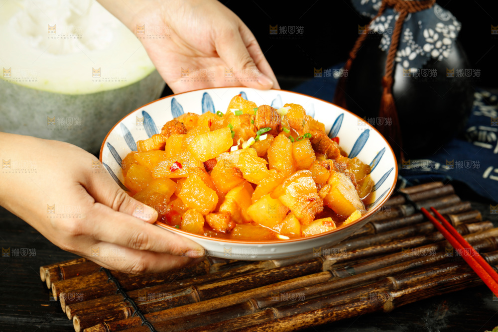 手里端着一盘冬瓜红烧肉