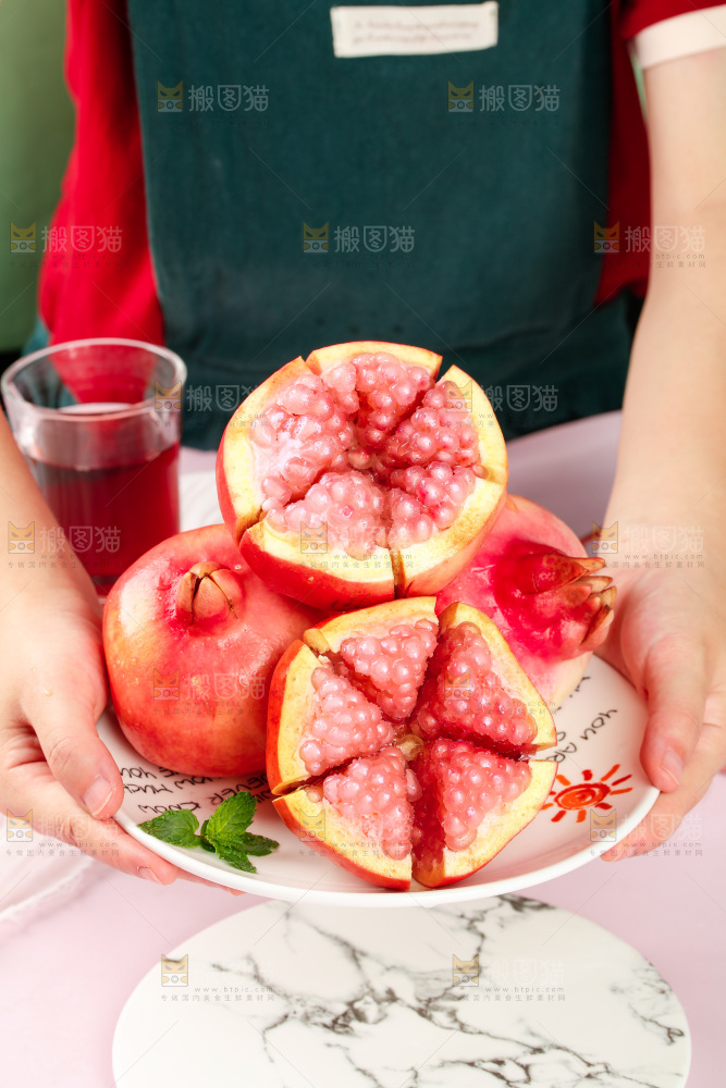 手里端着一盘水晶石榴