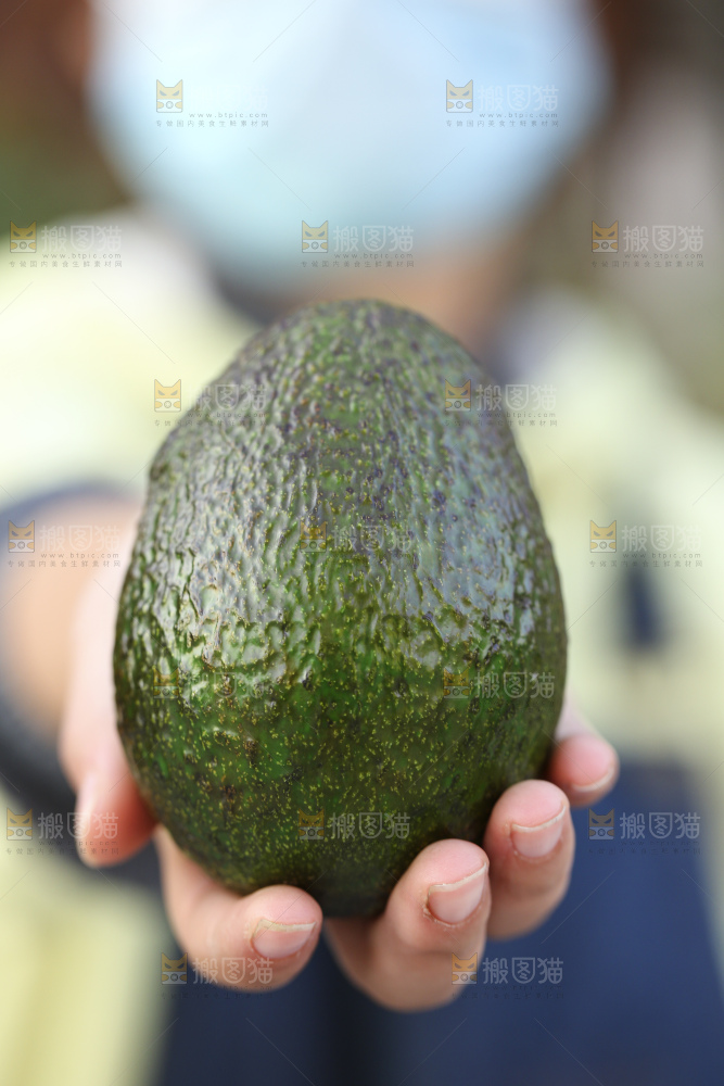 手里拿着秘鲁牛油果