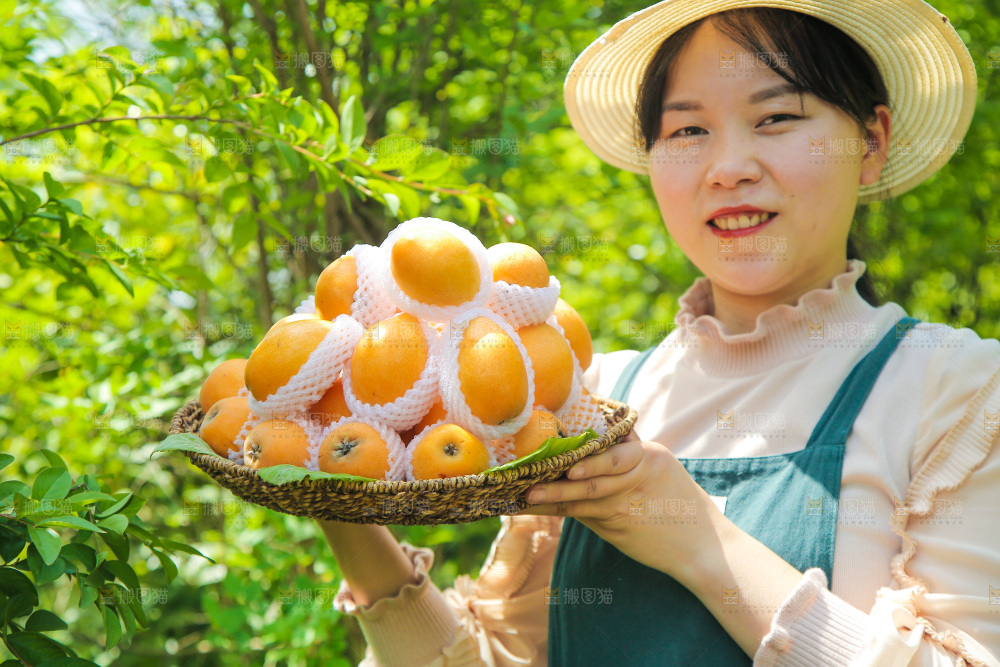 女人手里端着一篮大枇杷