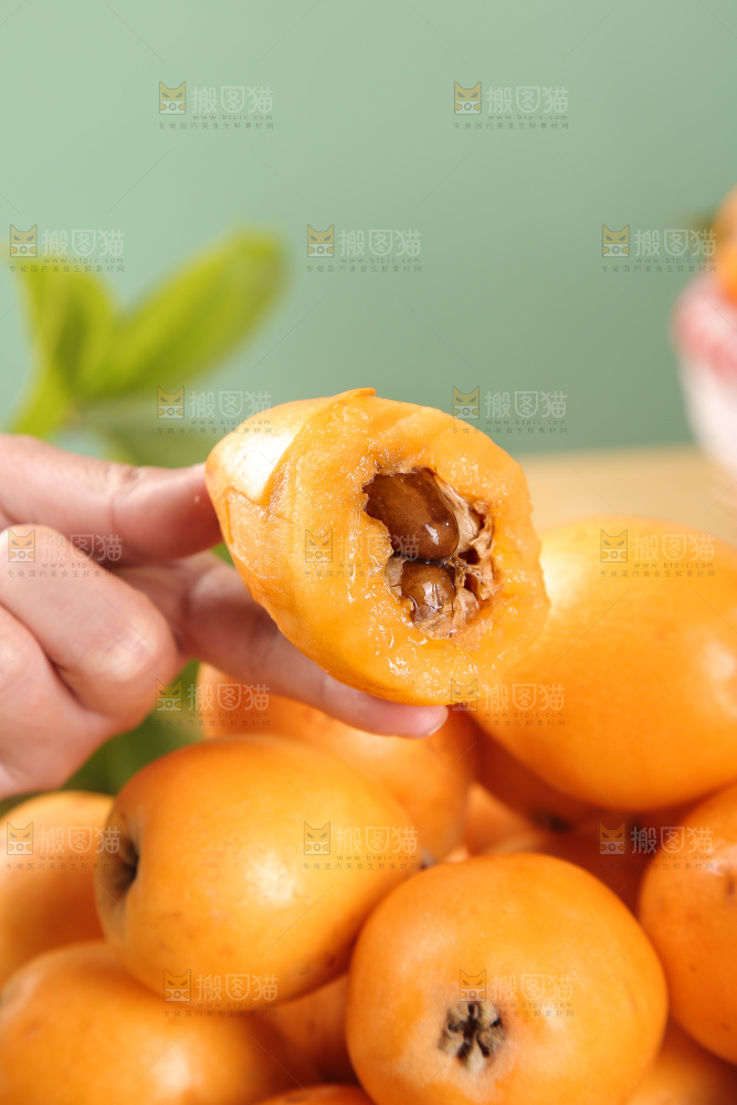 手里拿着新鲜枇杷