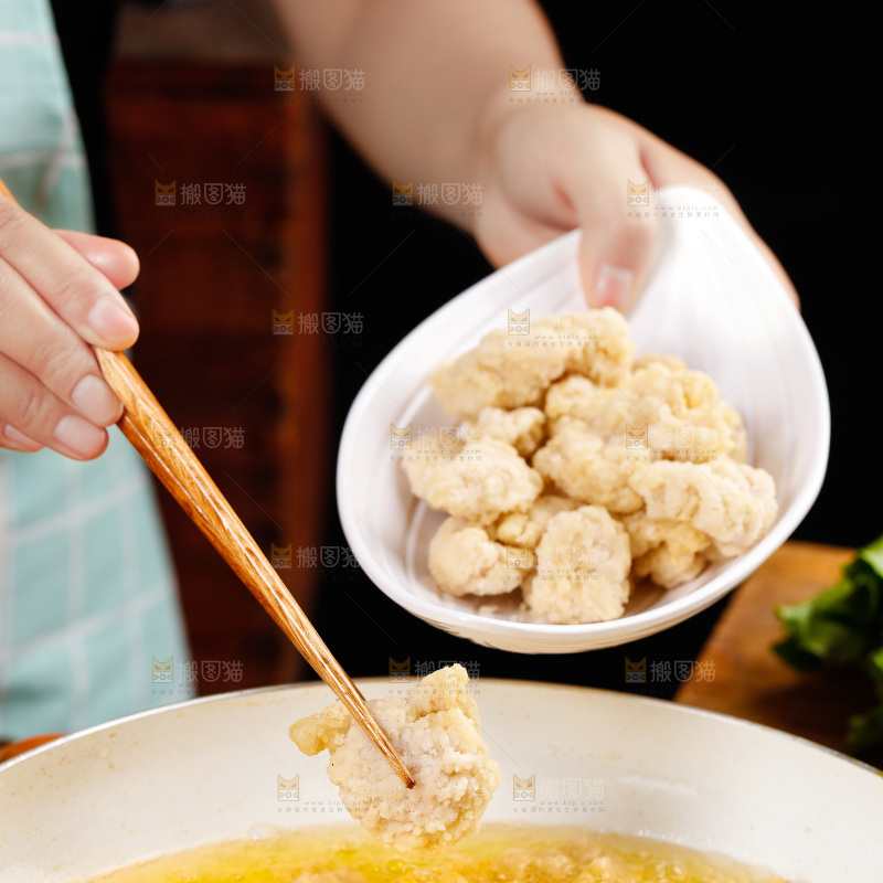 手上端着一盘盐酥鸡和筷子上夹着鸡块