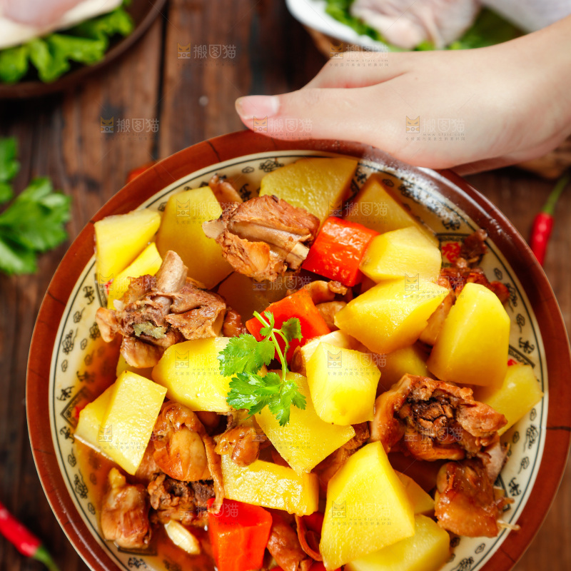 盘子里放着土豆烧鸡腿