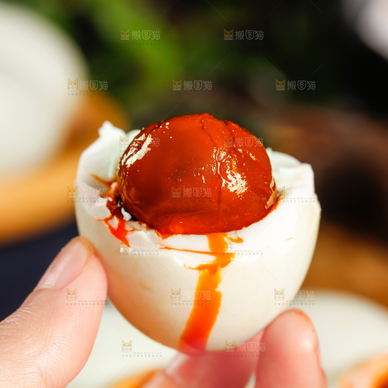 木板上手拿流油的海鸭蛋