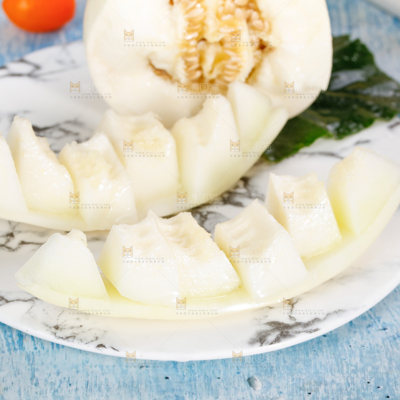 蓝底上放着一盘切开的阎良蜜瓜