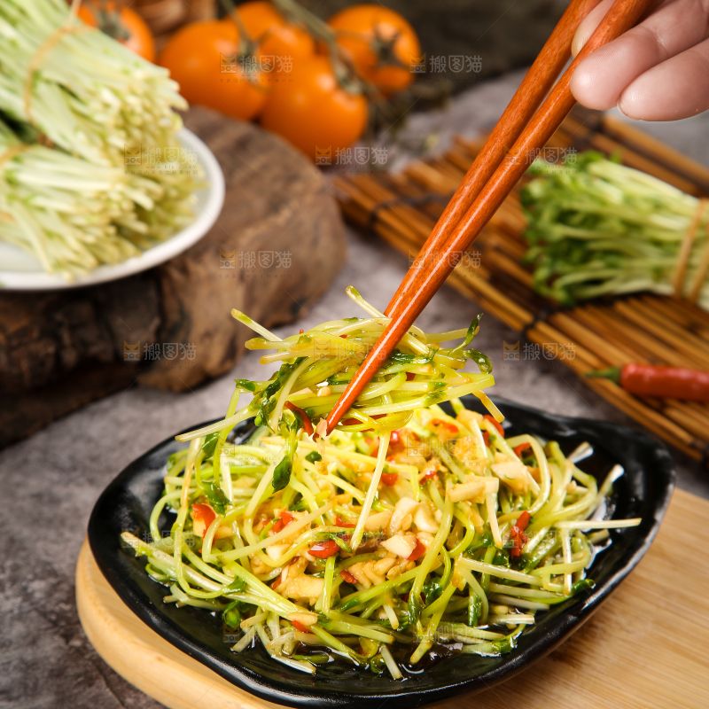 盘子里装着炒豌豆芽苗菜