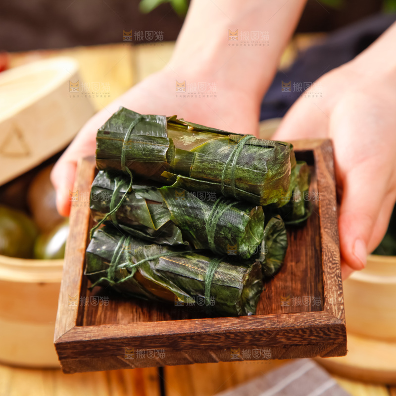 手里拿着竹筒肉粽
