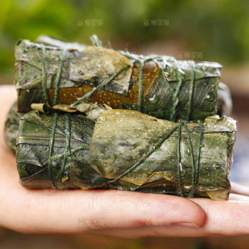 手里拿着竹筒糯米饭