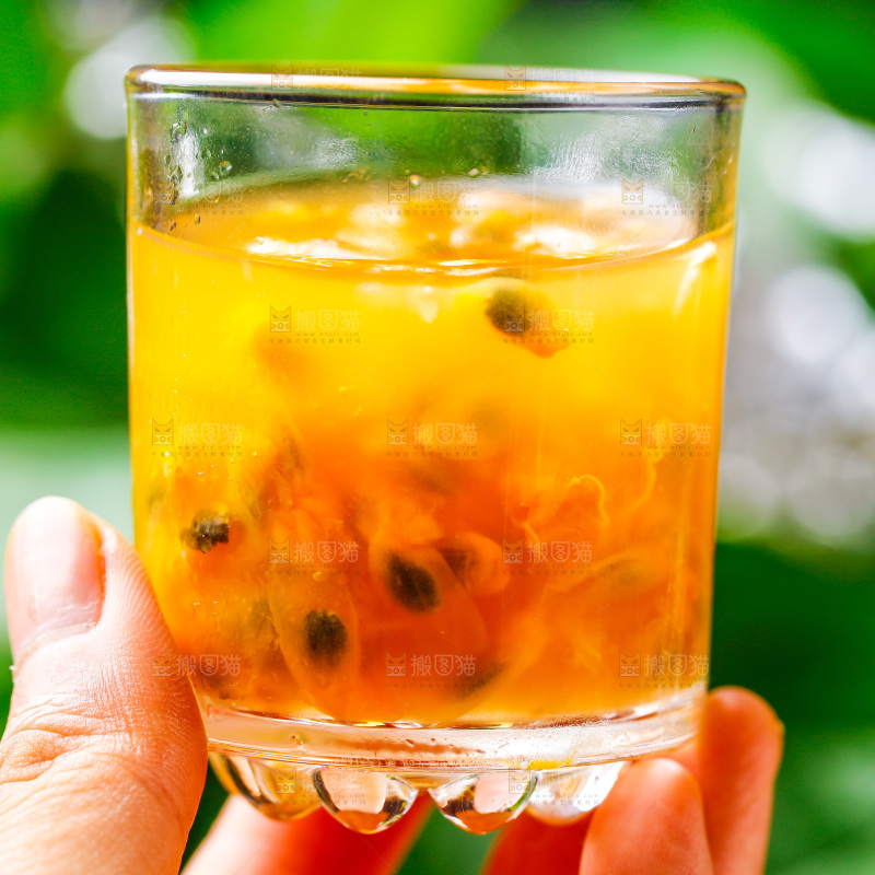 手里拿着一杯黄金百香果果汁