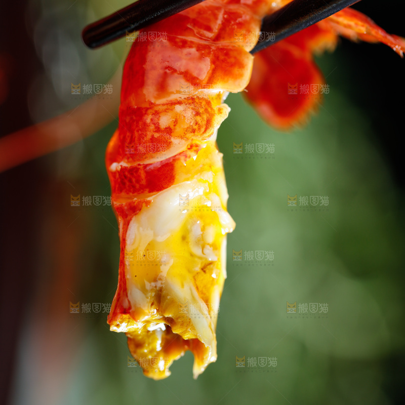 筷子夹着龙虾尾