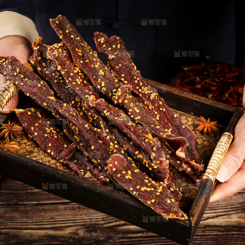 手里端着一盘牛肉干