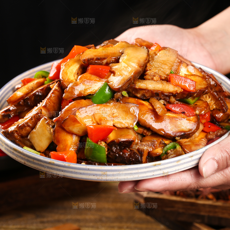 手里端着一盘花菇炒肉
