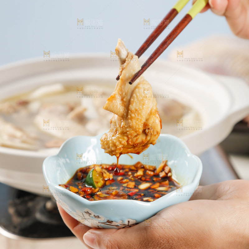 筷子上夹着蘸汁的椰子鸡