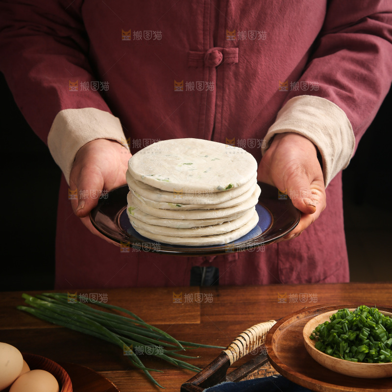 手里端着一盘葱油饼