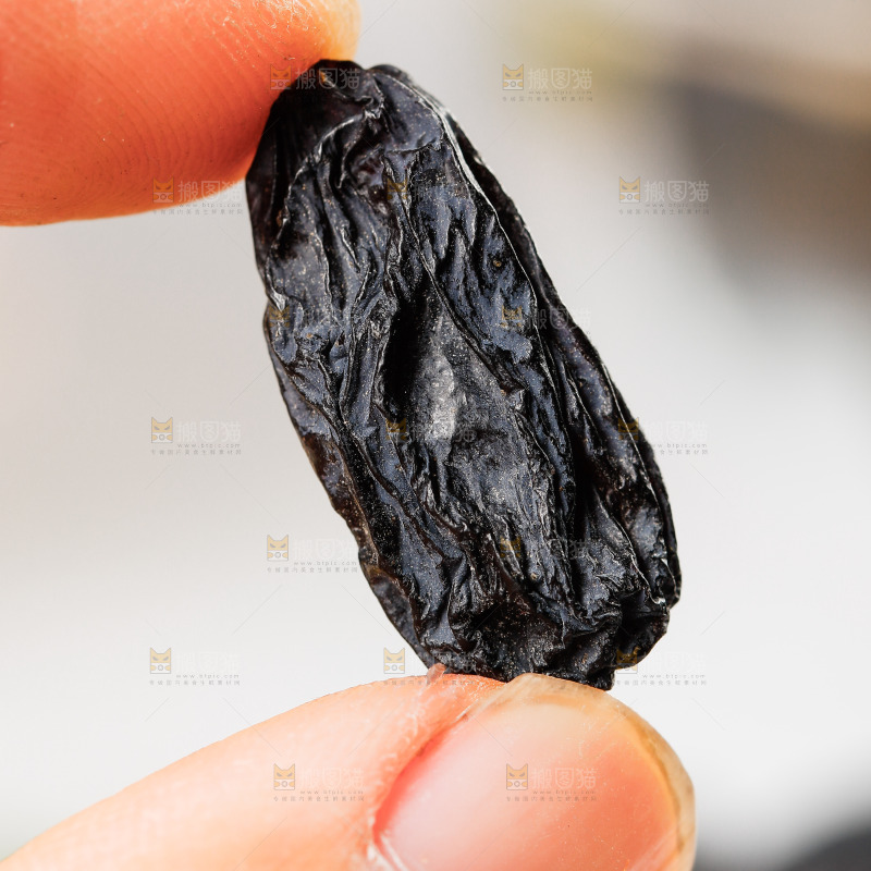 手里拿着黑葡萄干