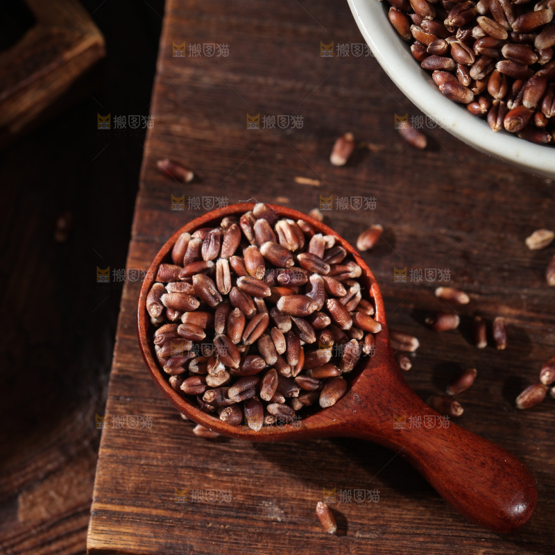木板上放着一勺黑小麦