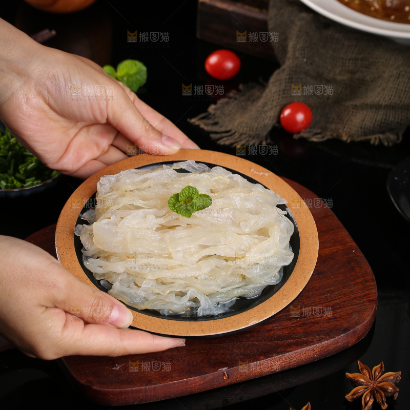 手里端着一盘海蜇丝