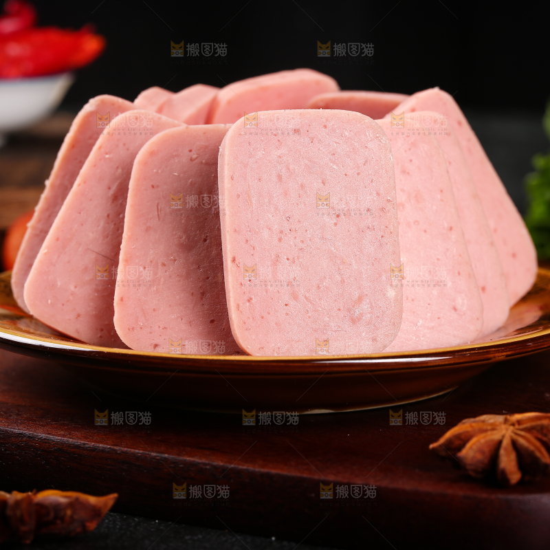 木板上放着一盘切片的午餐肉