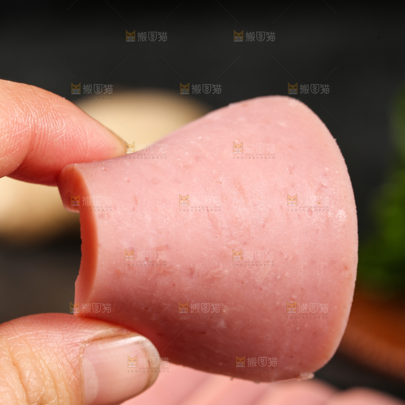 手里拿着切片的午餐肉