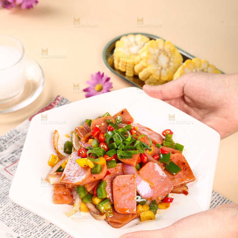 手里端着一盘辣椒炒火腿肉