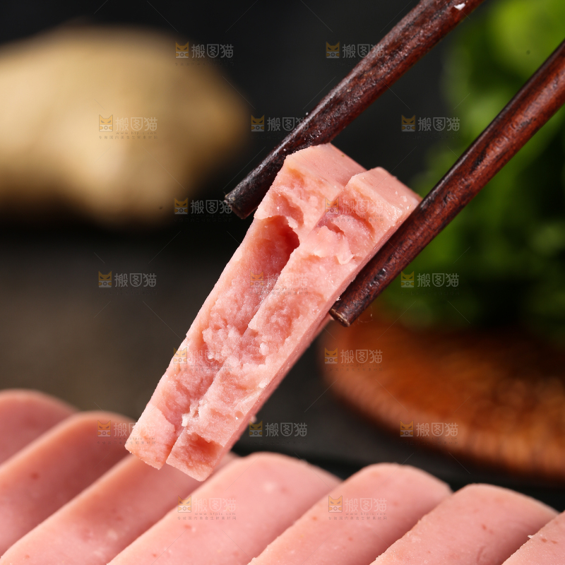 筷子上夹着切块的午餐肉